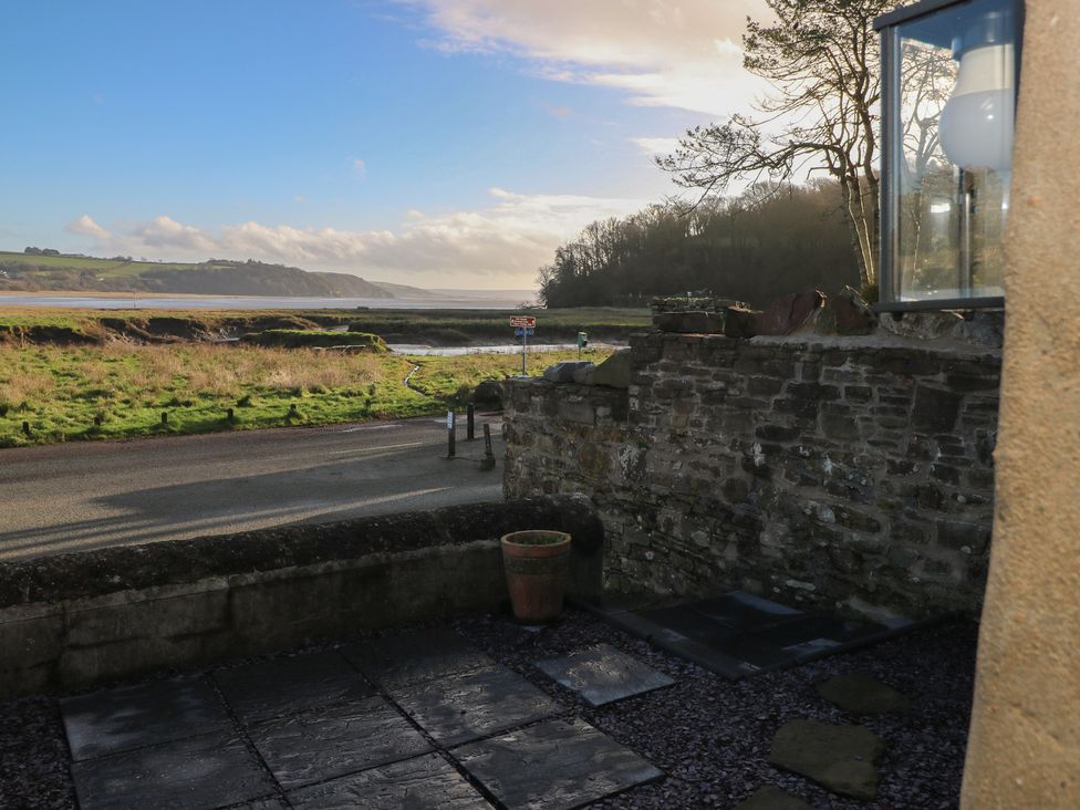An outdoor area with a view of grass and water at 2 Strand Cottages in Carmarthen