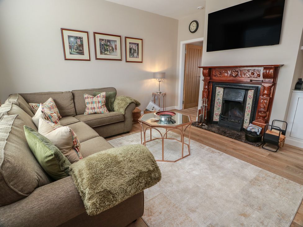 A living room with a sofa and fireplace at Castaway Cottage Maidens