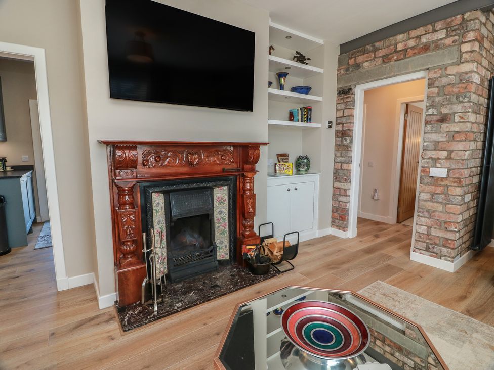 A living room with a television and fireplace at Castaway Cottage Maidens