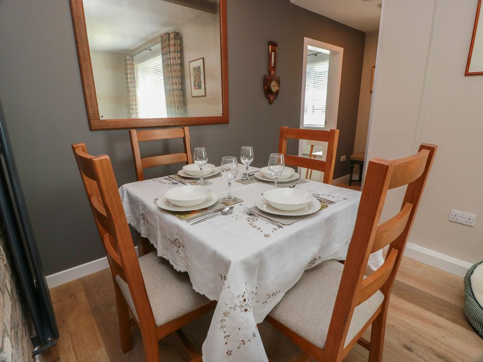 A dining room with a table set for meals at Castaway Cottage Maidens