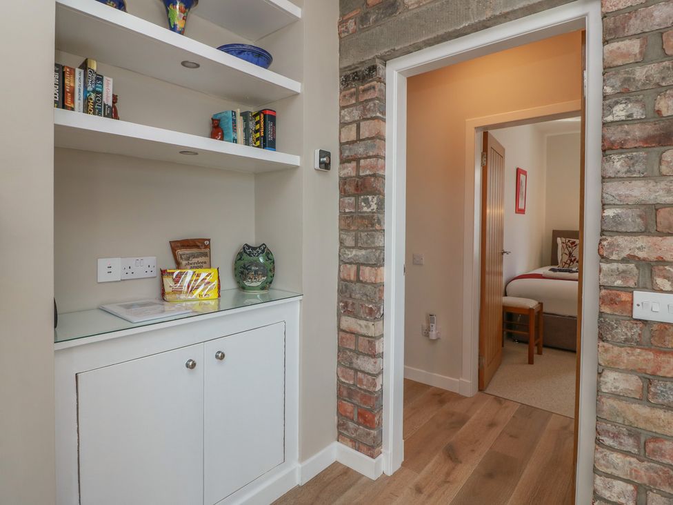 A hallway with shelves and books at Castaway Cottage Maidens