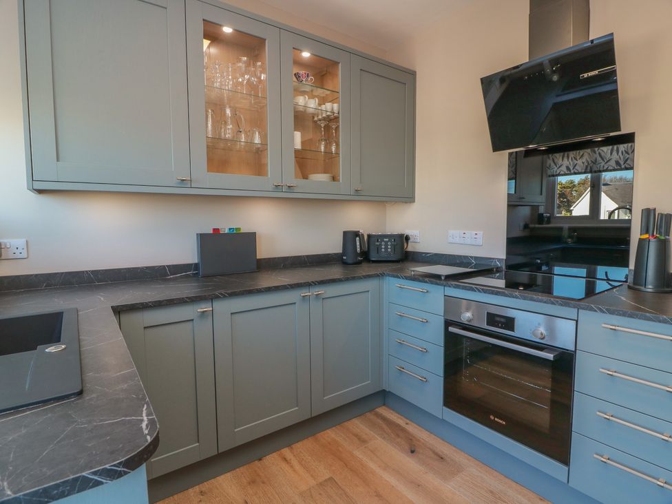 A kitchen with cabinetry, sink, oven, and countertops at Castaway Cottage Maidens