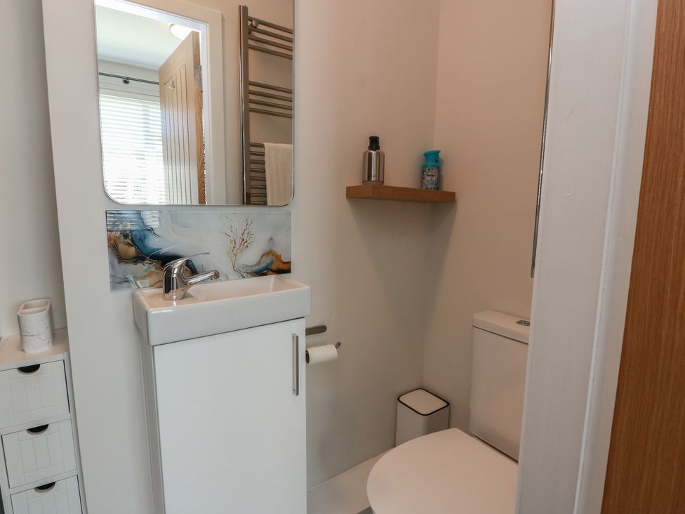 A bathroom with a sink and toilet at Castaway Cottage Maidens