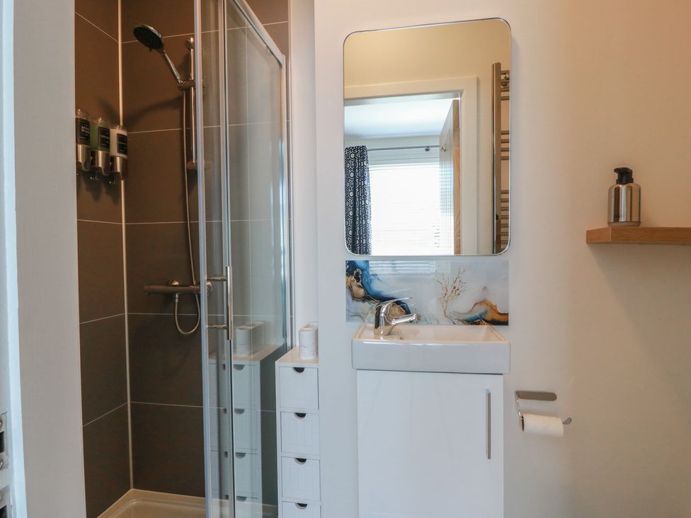A bathroom with a shower and sink at Castaway Cottage Maidens