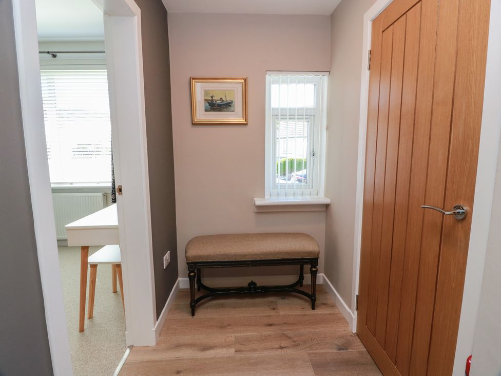 A hallway with a bench and window at Castaway Cottage Maidens