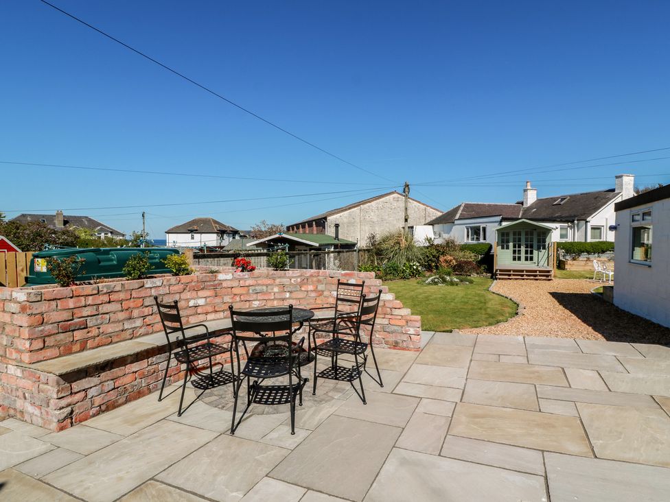 A garden with a seating area and lawn at Castaway Cottage Maidens