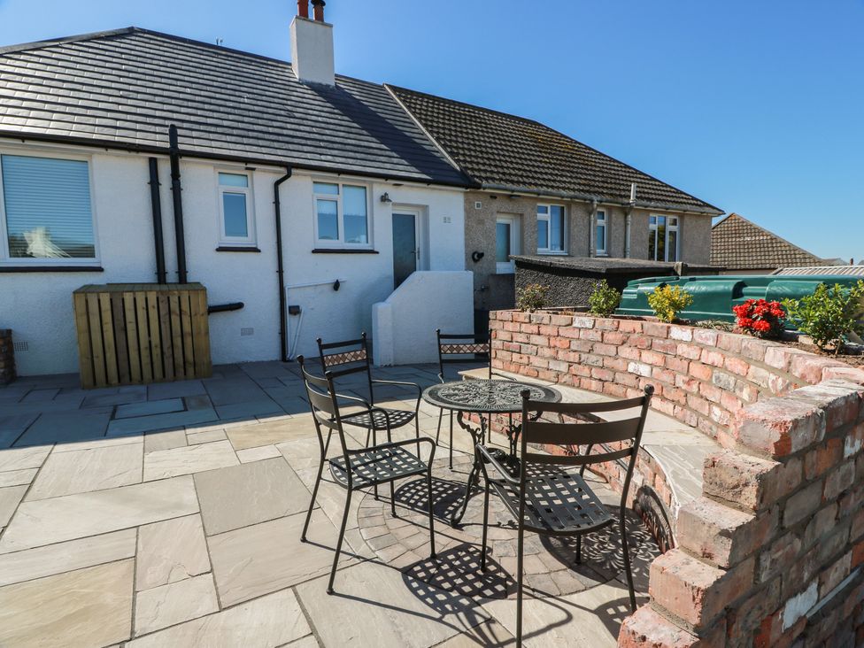 An outdoor patio with a table and chairs at Castaway Cottage Maidens