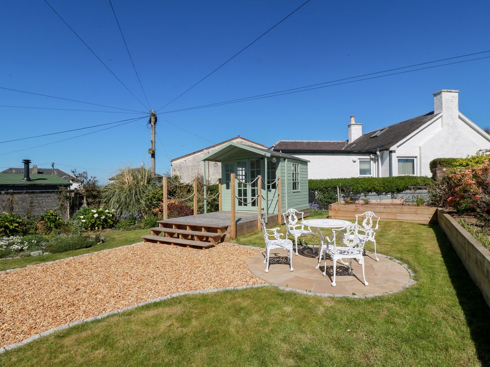 A garden with a seating area and a shed at Castaway Cottage Maidens