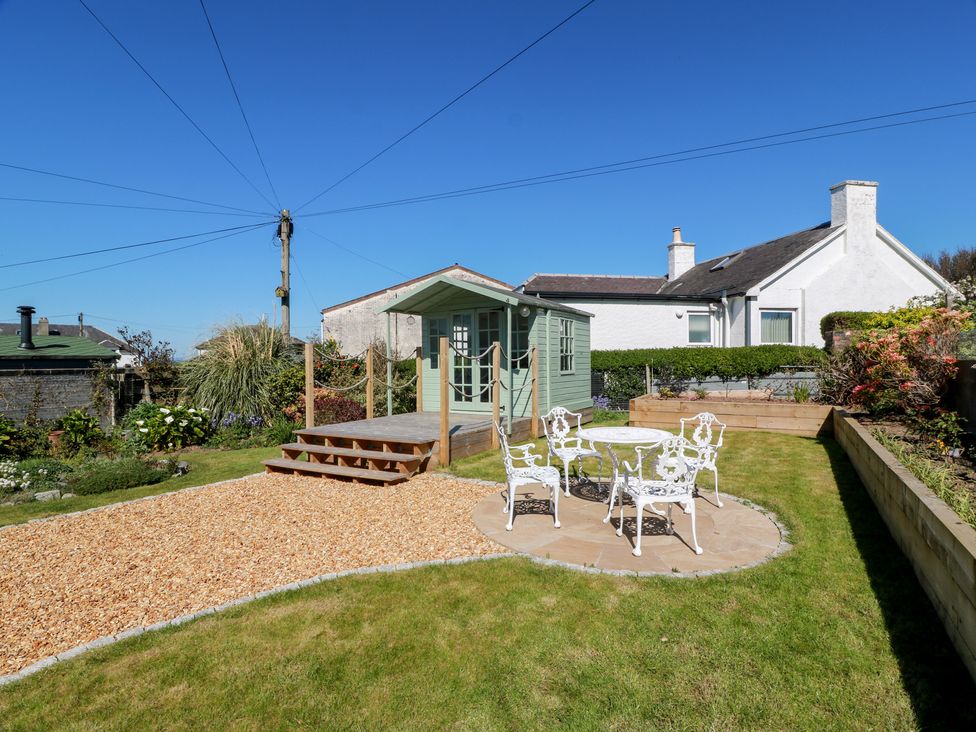 A garden with a shed and seating area at Castaway Cottage Maidens