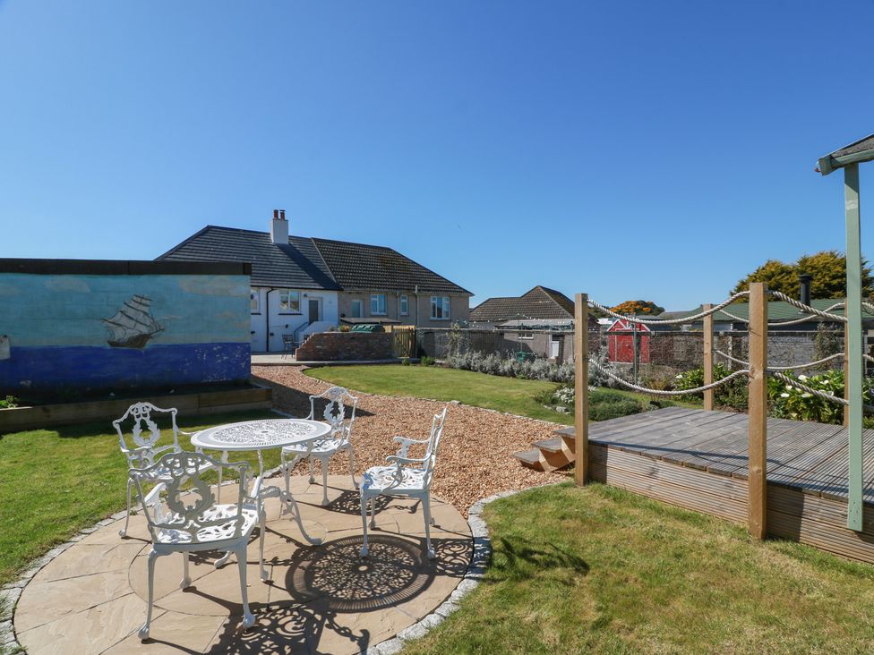 A garden with a table and chairs at Castaway Cottage Maidens