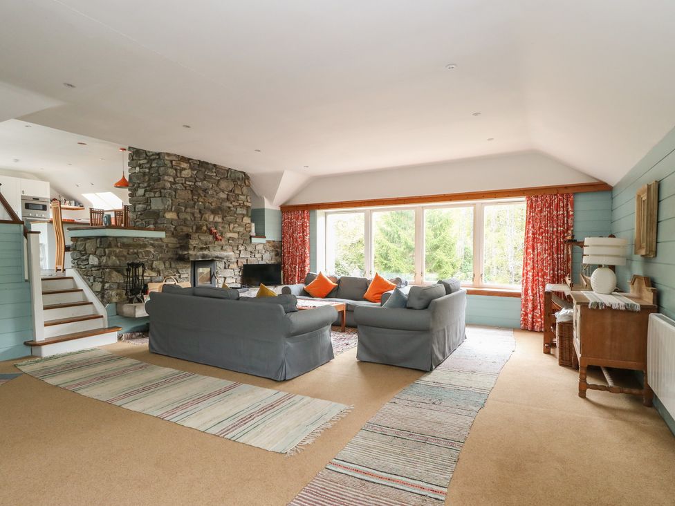 A living room with a sofa and fireplace at Culearn Mill in Balquhidder, Perthshire, Scotland