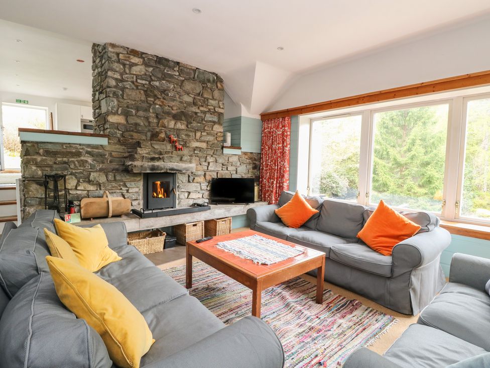 A living room with a fireplace and seating area at Culearn Mill Balquhidder, Perthshire, Scotland