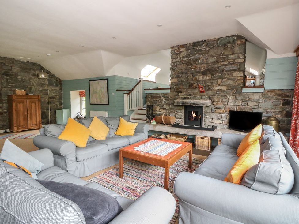 A living room with a fireplace and sofa at Culearn Mill, Balquhidder, Perthshire, Scotland