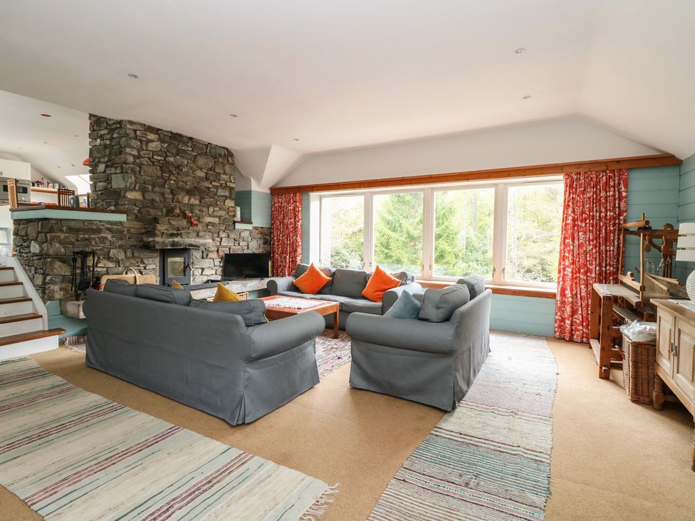 A living room with a fireplace and sofas at Culearn Mill in Balquhidder, Perthshire, Scotland