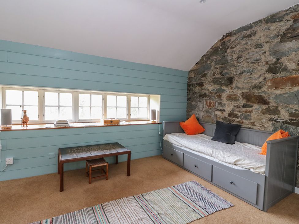 A bedroom with a bed and a bench at Culearn Mill in Balquhidder, Perthshire, Scotland