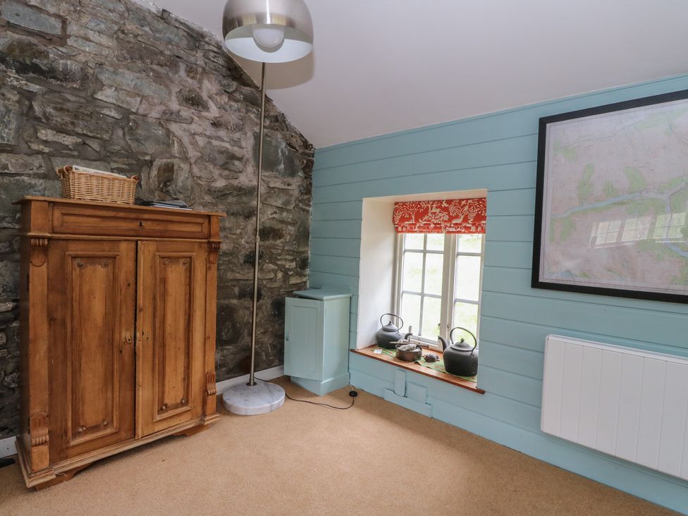 A snug with a wardrobe and floor lamp at Culearn Mill Balquhidder, Perthshire, Scotland