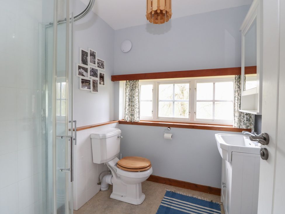 A bathroom with a shower, toilet, and sink at Culearn Mill, Balquhidder, Perthshire, Scotland