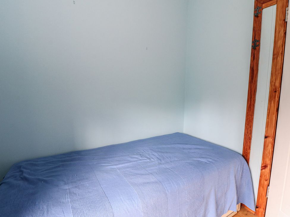 A bedroom with a bed and door at Culearn Mill Balquhidder, Perthshire, Scotland