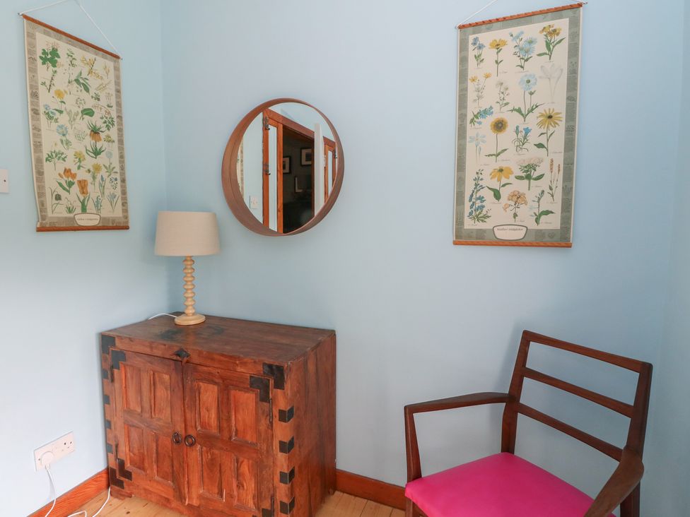 An entryway with lamp, mirror, cabinet, and chair at Culearn Mill in Balquhidder, Perthshire, Scotland