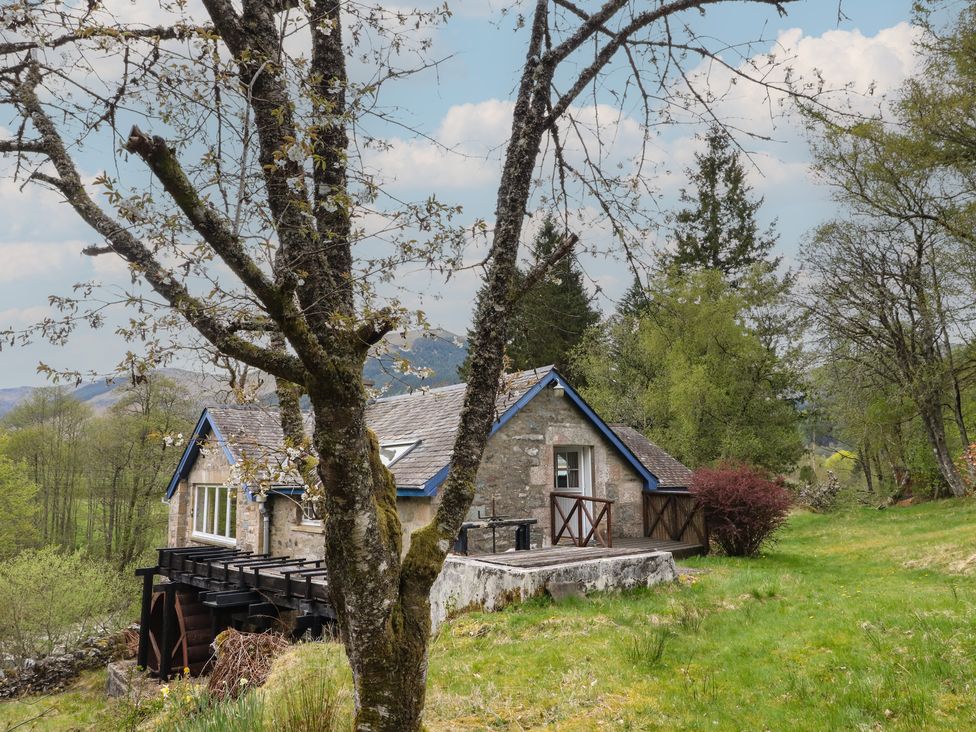 A cabin surrounded by trees and grass at Culearn Mill in Balquhidder, Perthshire, Scotland