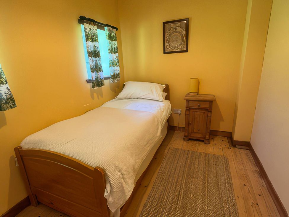 A bedroom with a bed and nightstand at Culearn Mill, Balquhidder, Perthshire, Scotland