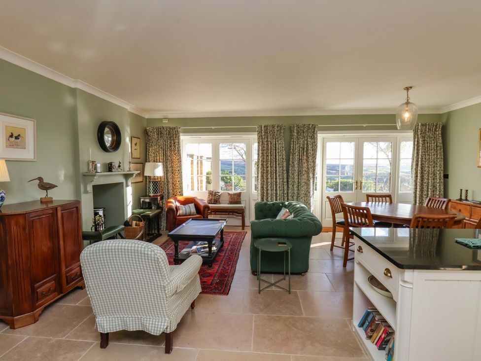 A living room with sofas and a dining area at Roding Cottage in Egton