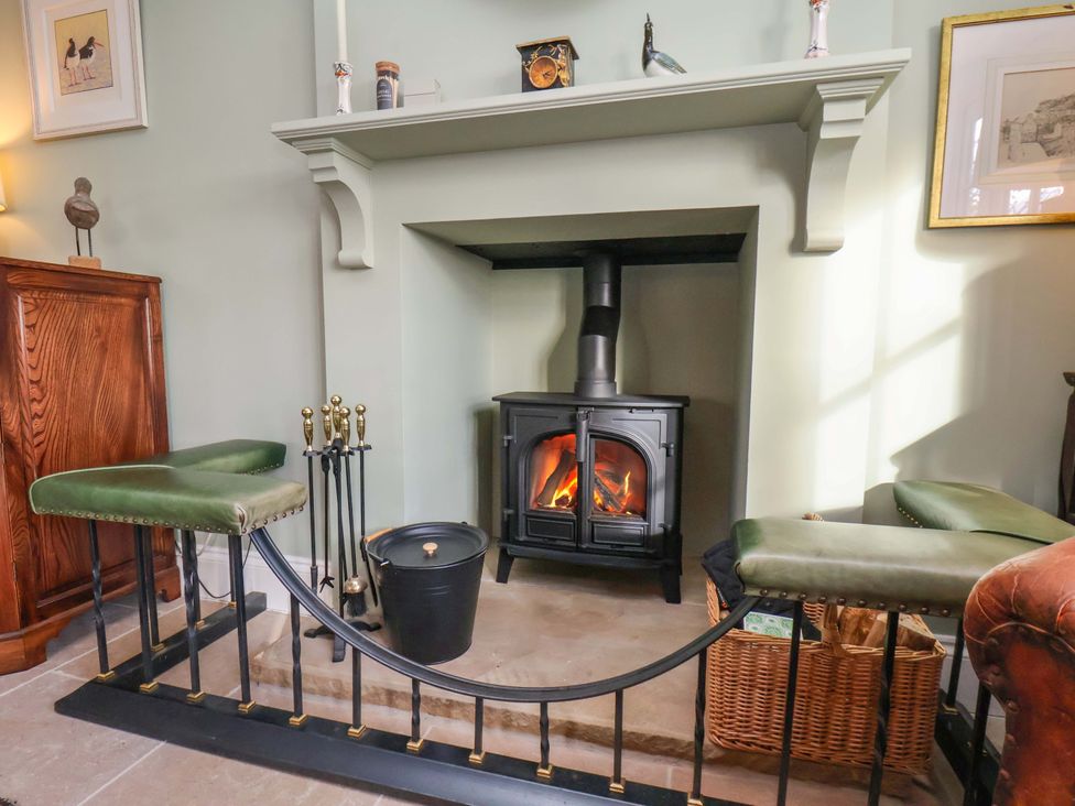 A living room with a fireplace and seating area at Roding Cottage in Egton