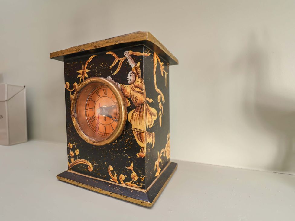 A decorative clock on a surface at Roding Cottage in Egton