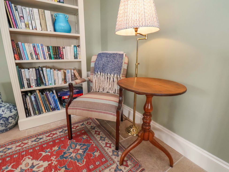 A reading nook with a chair and lamp at Roding Cottage in Egton