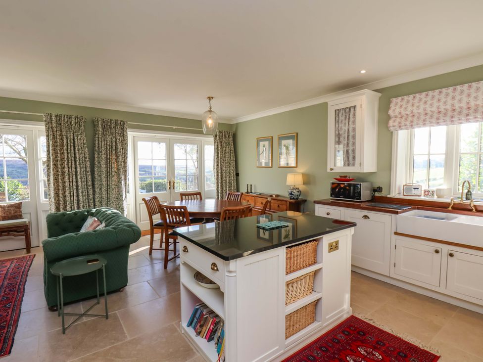 A kitchen with a dining table and chairs at Roding Cottage in Egton