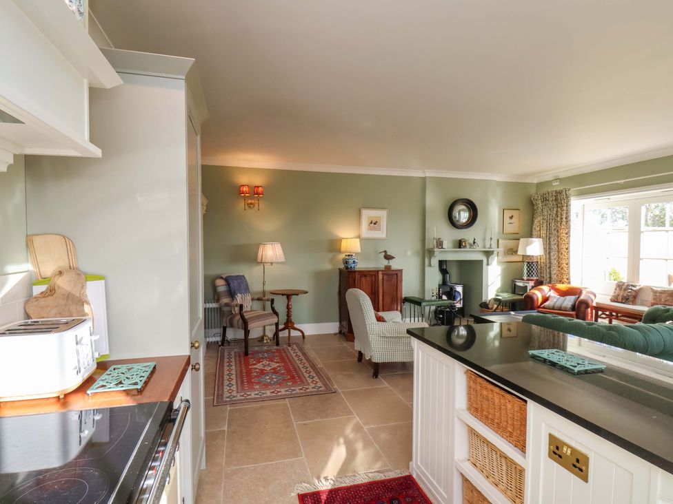 A living room with furniture and a kitchen area at Roding Cottage in Egton