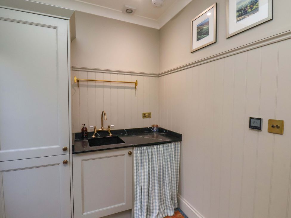 A kitchen with a sink and shelves at Roding Cottage in Egton