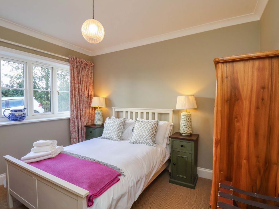 A bedroom with a bed and nightstands at Roding Cottage in Egton