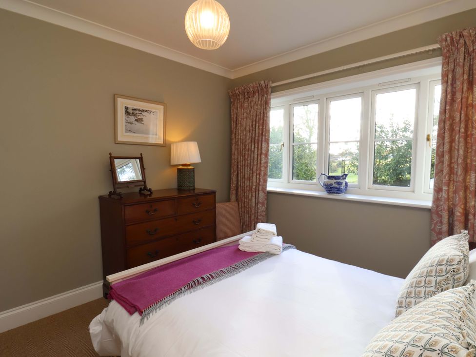A bedroom with a bed and dresser at Roding Cottage in Egton