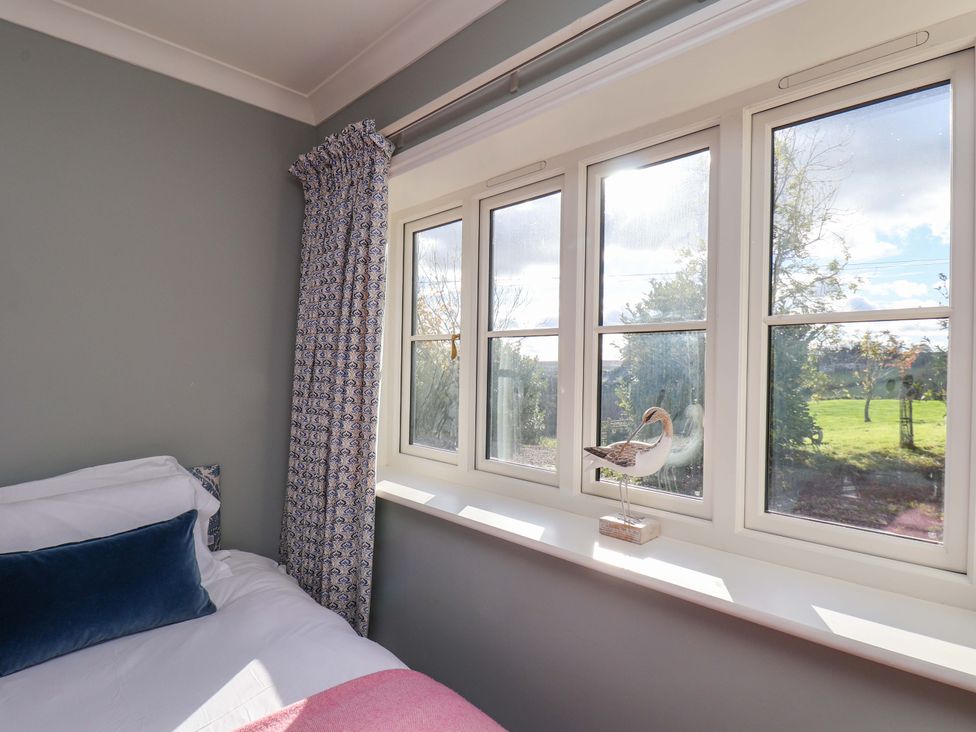 A bedroom with a bed and window at Roding Cottage in Egton