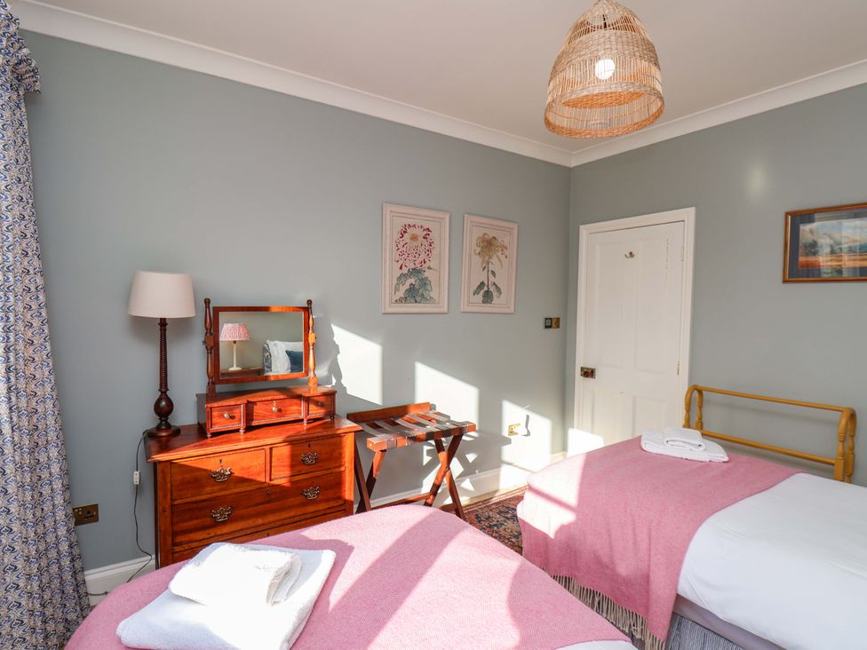 A bedroom with two beds and a nightstand at Roding Cottage in Egton