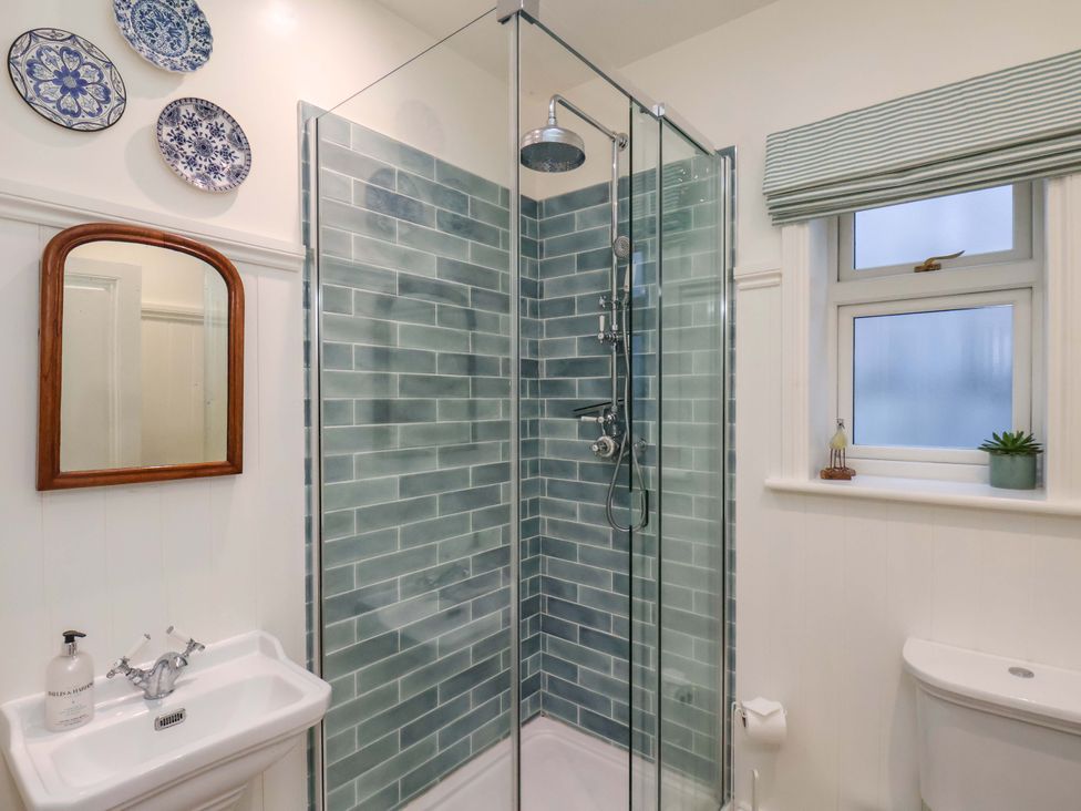 A bathroom with a shower, sink, and toilet at Roding Cottage, Egton