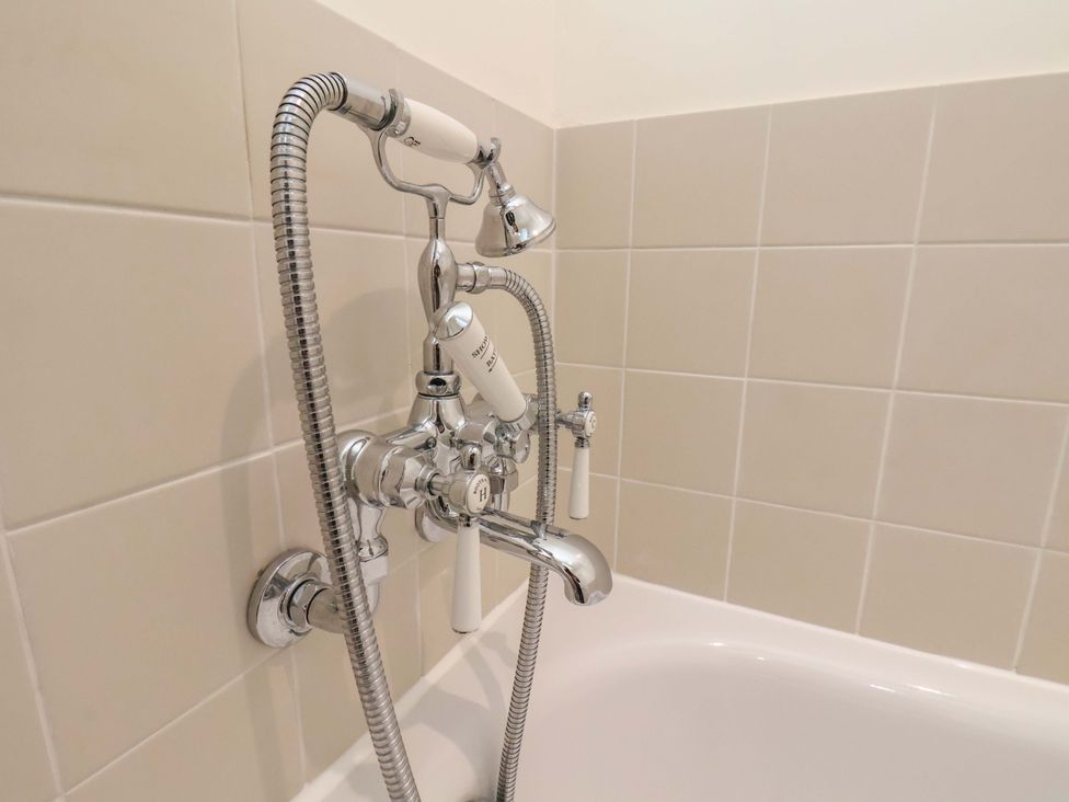 A bathtub faucet with showerhead at Roding Cottage in Egton