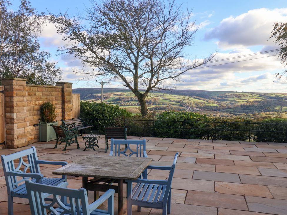 An outdoor patio with a table and chairs overlooking a valley at Roding Cottage in Egton