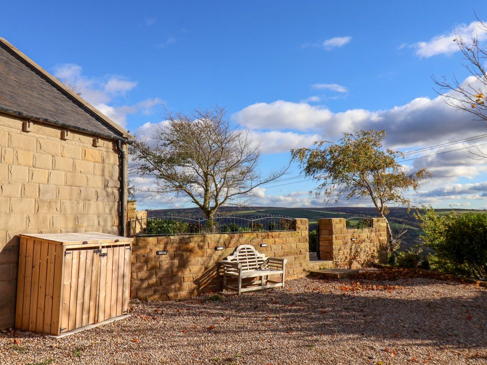 An outdoor space with a wooden storage box and a bench at Roding Cottage Egton