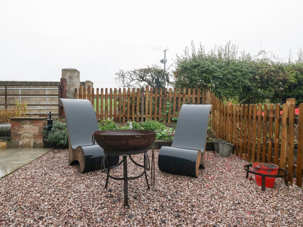 A garden with chairs and a fire pit at The Hay Barn in Huntley