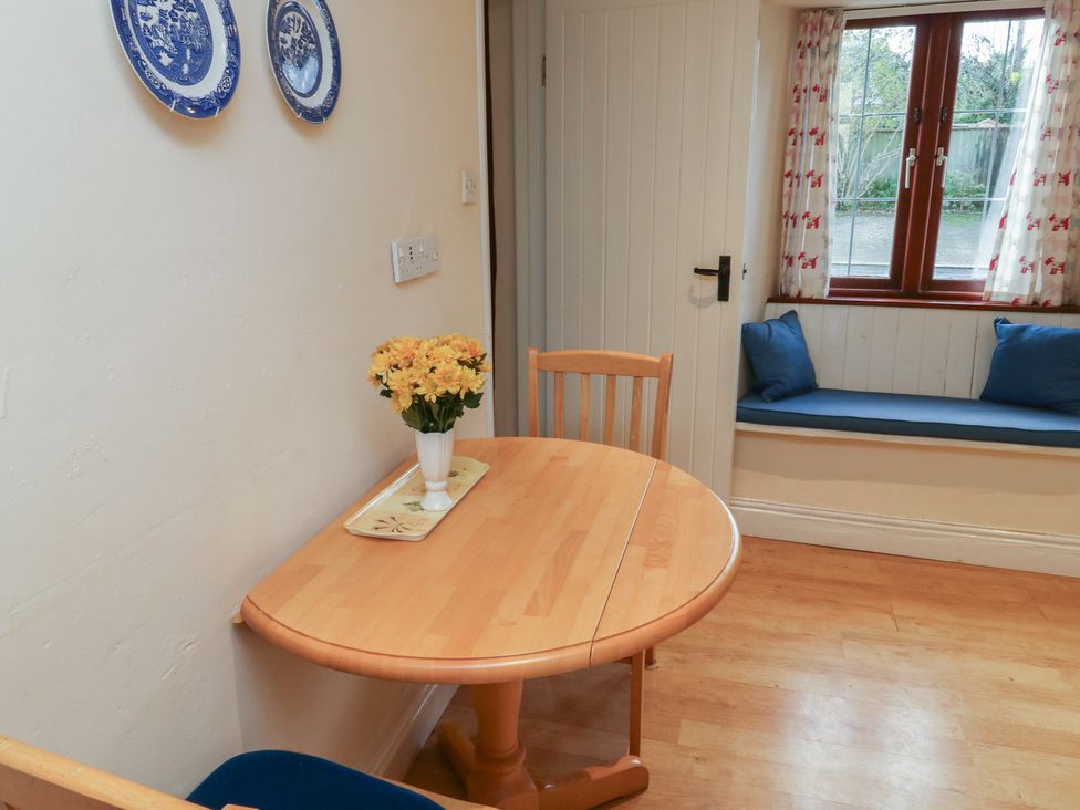 A dining room with a table and chairs at Bridge Cottage in Budleigh Salterton