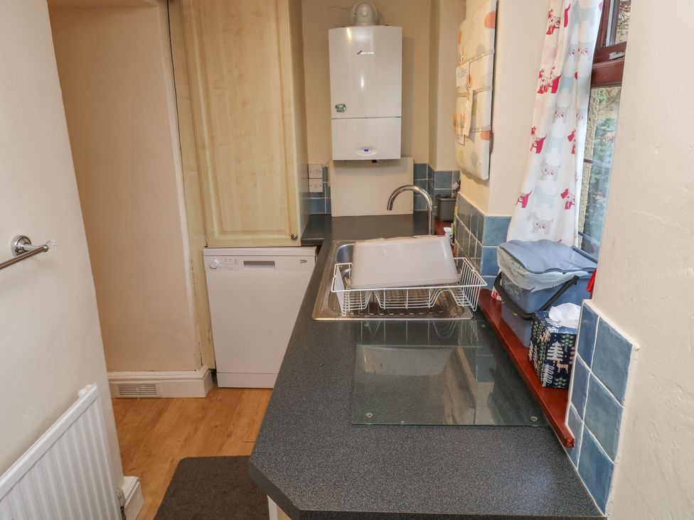 A kitchen with a sink and dishwasher at Bridge Cottage in Budleigh Salterton
