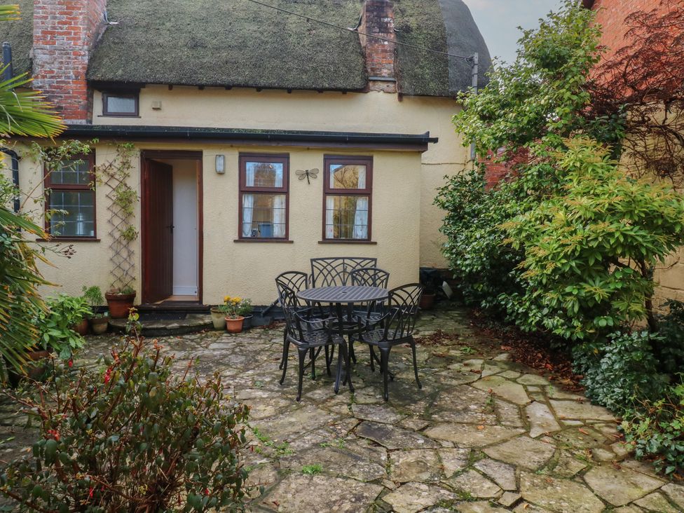 A garden with a table and chairs at Bridge Cottage in Budleigh Salterton
