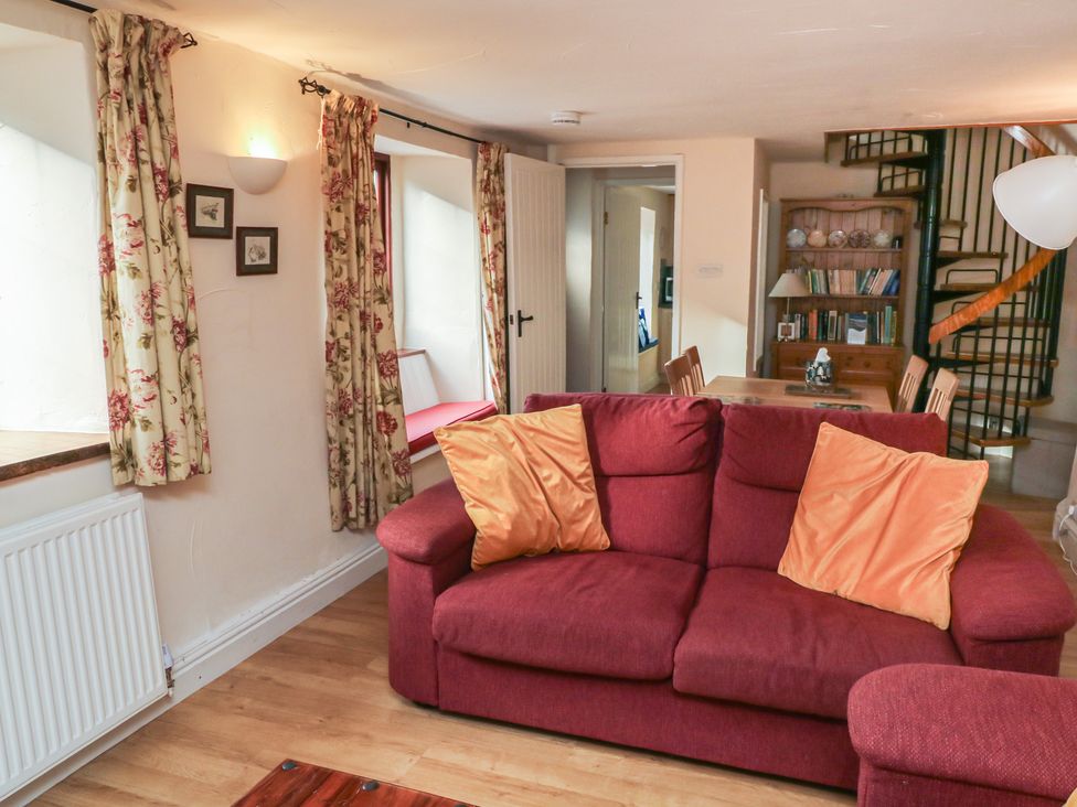 A living room with a sofa and dining area at Bridge Cottage Budleigh Salterton