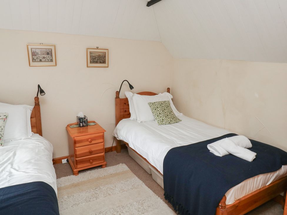 A bedroom with two beds and a nightstand at Bridge Cottage Budleigh Salterton