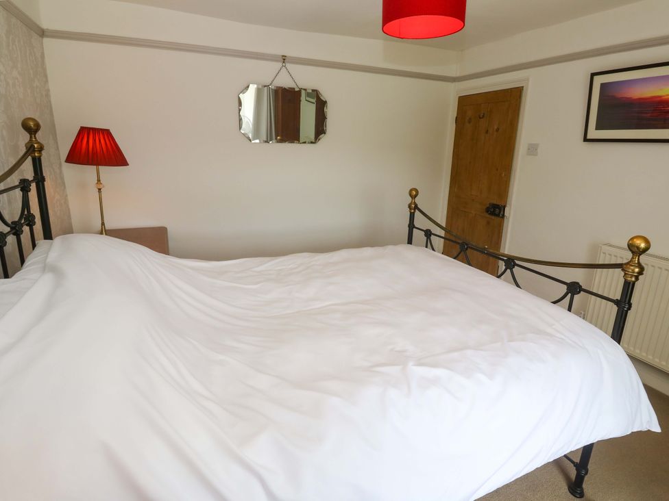 A bedroom with a bed and lamp at Greenways in Perranporth