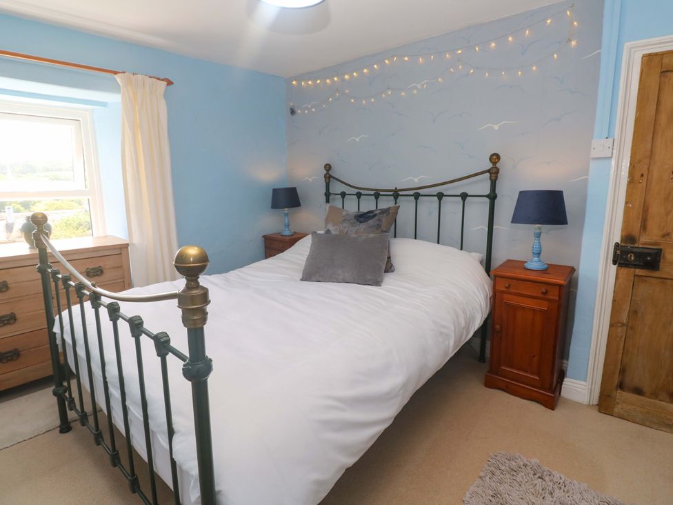 A bedroom with a bed and bedside table at Greenways in Perranporth
