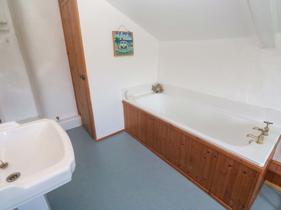 A bathroom with a bathtub and sink at Greenways Perranporth