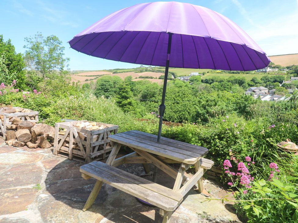An outdoor seating area with a table and purple umbrella at Greenways in Perranporth